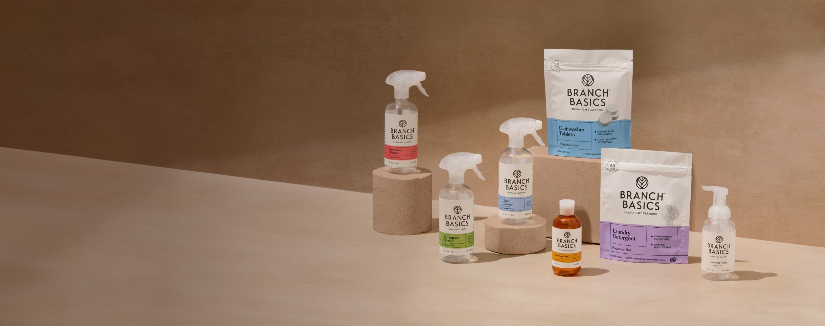 Assorted home cleaning products on a warm beige background